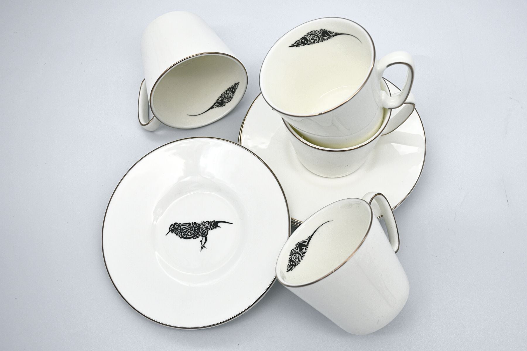 Coffee cups with detailed artistic bird motifs
