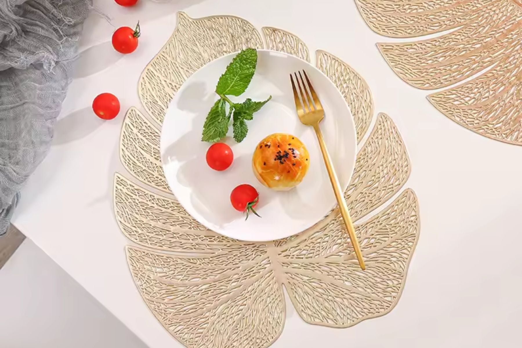Metallic gold table mat in the shape of a leaf