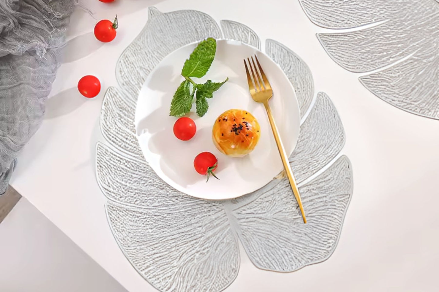 Metallic dining placemat shaped like a leaf
