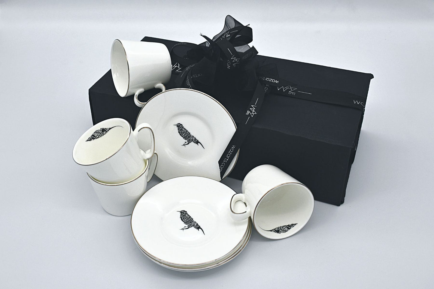 Elegant ceramic coffee cups with soft-toned bird imagery
